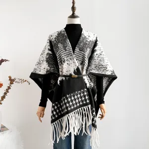 Detail of British style houndstooth knit shawl with long white fringe and waist belt