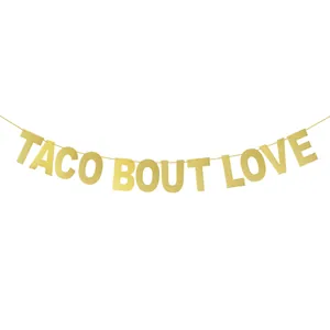 Close-up of gold glitter Taco Bout Love banner letters on white background for wedding decor