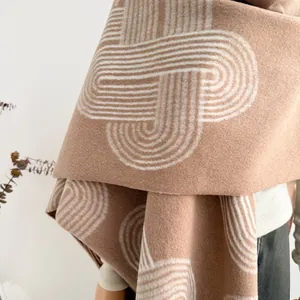 Close-up of camel geometric shawl featuring thick fabric texture and elegant fringe detail