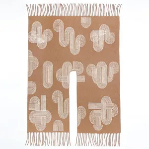 Close-up of brown shawl with white geometric patterns and long decorative tassels