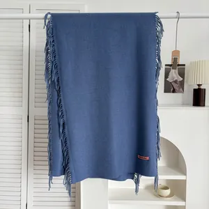Vue détaillée de l'écharpe bleu marine aspect cachemire avec franges et étiquette