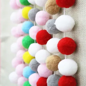 Close-up of colorful plush pom pom garland with soft texture for birthday party decoration