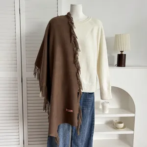 Détail d'une écharpe marron foncé avec franges et étiquette de marque en studio