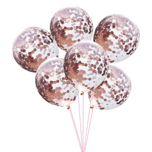 Close-up of six transparent latex balloons with rose gold metallic confetti and pink ribbons