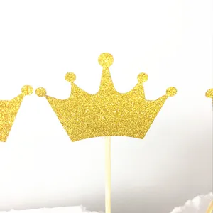 Close-up of glitter gold crown cake topper with sparkling texture and wooden stick