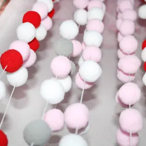 Colorful plush pompom garland for kids' party decoration featuring red, pink, and grey balls