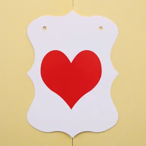 Dettaglio di etichette regalo a forma di cuore con stampa rossa e bordi decorativi