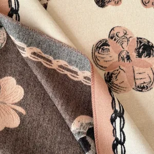 Gros plan de la texture du foulard camélia avec motif chaîne et bords rose doux