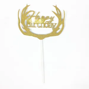 Close-up of golden glitter Happy Birthday cake topper with elegant antler design