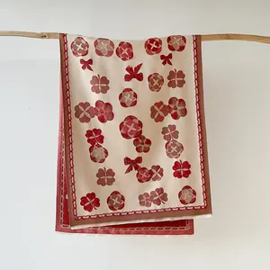 Détail d'un châle camélia élégant avec imprimés vintage et finitions à franges fines