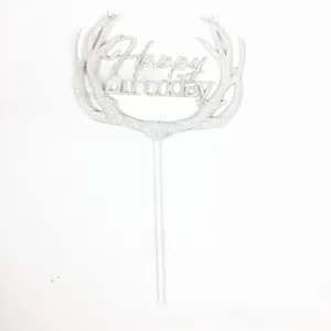 Macro detail of silver glitter Happy Birthday cake topper with elegant reindeer antlers