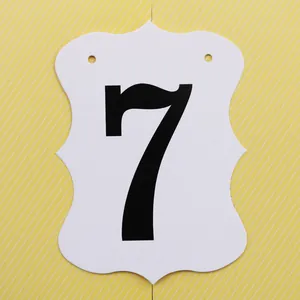 Dettaglio di carta smerlata bianca con numero sette nero per decorazioni di compleanno