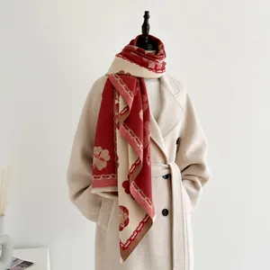 Détail de l'écharpe d'hiver en cachemire à motif camélia et finitions frangées