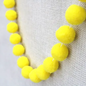 Detail of bright yellow handmade pom-pom garland for children's party decoration