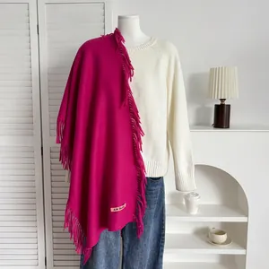 Vue détaillée d'une écharpe en cachemire magenta avec franges sur un mannequin
