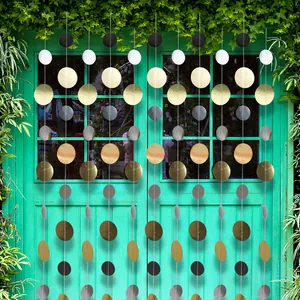 Verticale gouden en zilveren slingers hangend aan een groene deur voor feestdecoratie