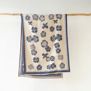 Détail d'une écharpe élégante à fleurs avec de douces franges blanches sur support
