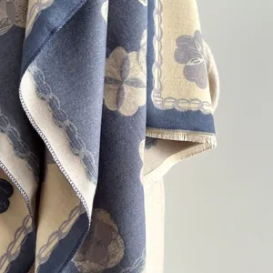 Détail du châle jacquard bleu et beige avec motif floral, tissage fin et franges