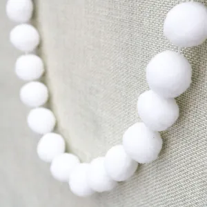 Close-up of soft white pom-pom garland for children's party DIY birthday decoration