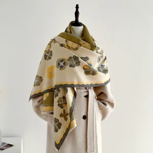 Gros plan sur une écharpe épaisse en cachemire à fleurs rétro sur manteau beige