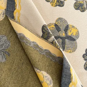 Détail macro du châle camélia montrant l'imprimé floral recto-verso et la couture de qualité