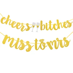 Close-up of gold glitter banners with cheers bitches and miss to mrs party lettering