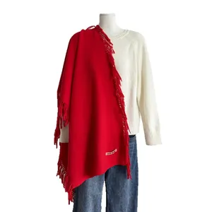 Écharpe rouge imitation cachemire à franges sur pull blanc et jean bleu denim