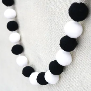 Close-up of black and white felt ball garland with soft fuzzy texture for party decor