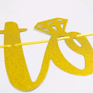 Detail of glittery gold wedding banner with diamond ring motif on premium glitter paper