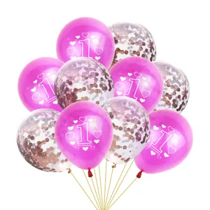 Détail de ballons du 1er anniversaire avec texte blanc et confettis or rose à l'intérieur