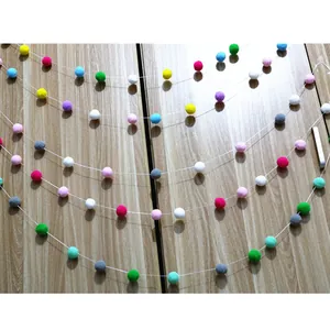 Close-up of colorful DIY felt pom pom garland for kids birthday party and home decoration