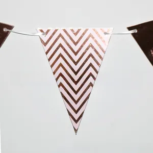 Detail of rose gold and pink wave pattern paper bunting flags with white silk ribbon