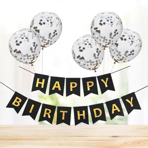 Detail of gold confetti balloons and black Happy Birthday banner for party decor