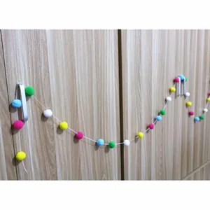 Close-up of colorful wool felt ball garland for children's birthday party wall decoration