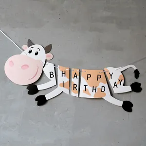 Cartoon cow themed Happy Birthday banner with black letters and white hanging string