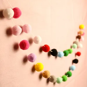 Colorful plush ball garland with fluffy pom poms for birthday party and DIY nursery decoration