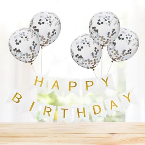 Close-up of Happy Birthday banner with sequin balloons on a light wood tabletop decor