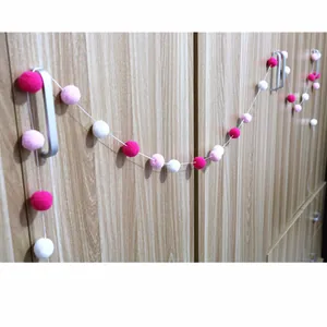 Colorful plush ball garland with pink and white pom poms for kids party decoration
