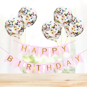 Pink and gold Happy Birthday banner paired with colorful confetti balloons on a table