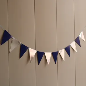 Close-up of metallic rose gold and dark blue triangle party banners with silver string