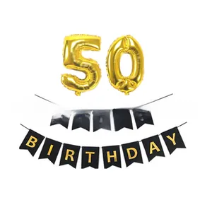 Détail de ballons dorés numéro 50 et bannière noire Happy Birthday pour la fête