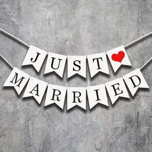 White Just Married wedding banner with red heart hanging on a modern grey wall