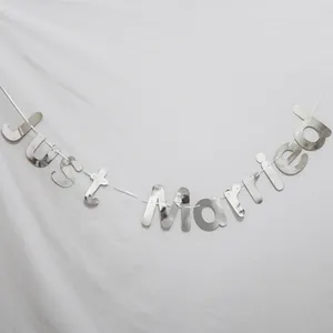 Dettaglio dello striscione Just Married argento a specchio con riflessi metallici