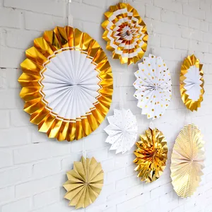 Detail of assorted gold and white paper fans with dots and stripes for party decor