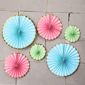 Detail of blue, pink, and green paper fans with elegant gold foil scalloped edges