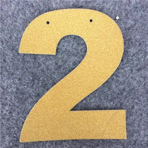 Dettaglio dell'etichetta glitterata oro champagne numero 2 con fori per appendere