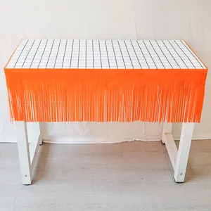 Jupe de table à franges orange avec bordure à carreaux noirs et blancs pour fête