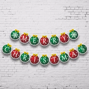 Kerst slinger met Merry Christmas letters en gouden strikken op een witte bakstenen muur