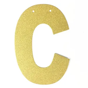 Détail de la décoration lettre C dorée pailletée avec trous pour bannière de fête
