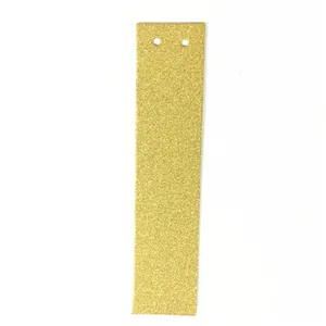Détail d'étiquette rectangulaire dorée à paillettes avec double perforation pour mariage